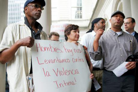 Group of men with one holding a sign.