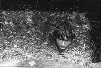 A Mumbai street cleaner up to his neck in a drain (Photo © Sudharak Olwe 2003)