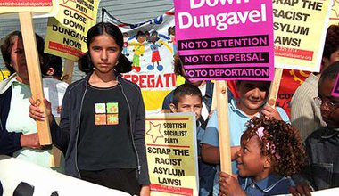 Children protest with signs and placards. Signs read No Detention, No Deportation