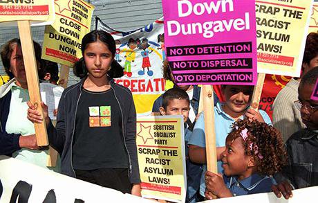 Children protest with signs and placards. Signs read No Detention, No Deportation