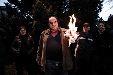 An anti-government protester burns a sign in Kranj, Slovenia. Luka Dakskobler. All rights reserved.