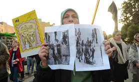 A protester holds pictures of a victim that was stripped by army forces in 2011. Demotix/Halim Elshaarani. Alll rights reserved.
