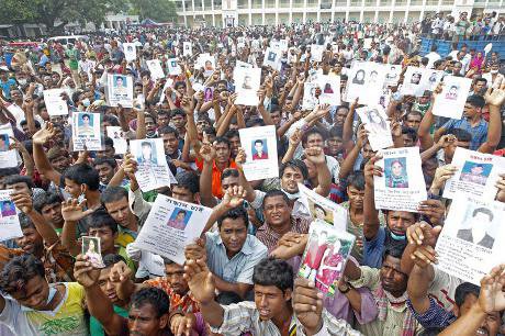 Relatives of the Savar tragedy victims hold the photos of their dear ones who still remain missing for the fifth day 