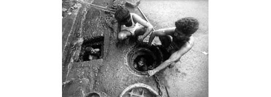 Cleaning drains (Photo © Sudharak Olwe 2003)