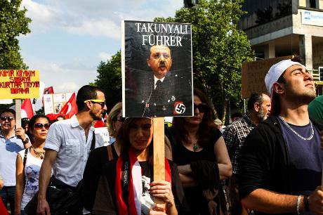 A picture of Turkish PM Recep Tayyip Erdogan dressed as a Nazi is seen as protesters stage a demonstration in Berlin 