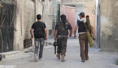 Free Syrian Army fighters carry their weapons to the frontline in Damascus