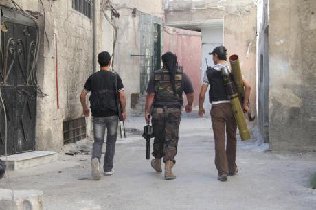 Free Syrian Army fighters carry their weapons to the frontline in Damascus