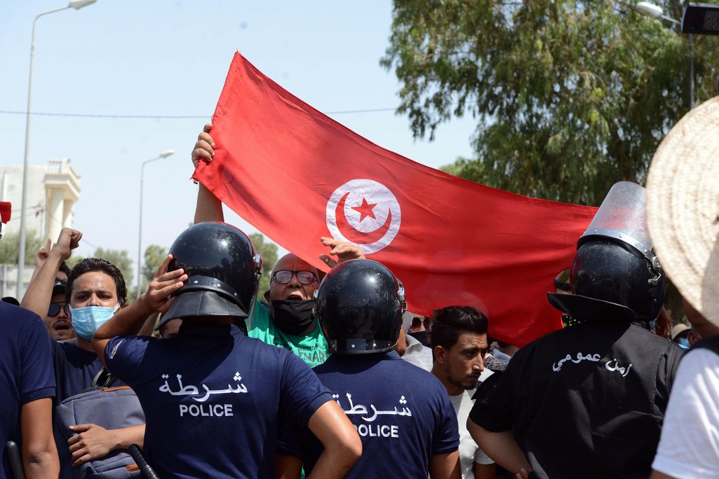 Police stand in front of clashes between citizens and members of the Ennahda Movement and the Al Karama Coalition.photo