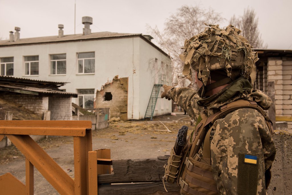 Un soldado ucraniano señala un edificio en el este del país que ha sido dañado por los bombardeos rusos