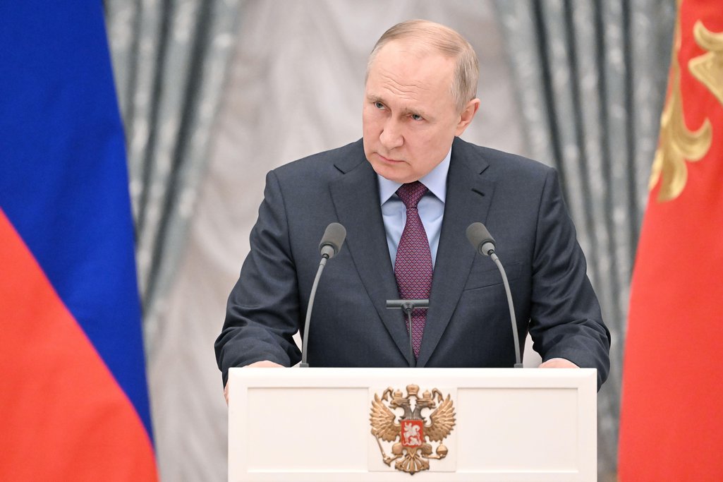 Russia's President Vladimir Putin stands behind a podium to give comments to the media