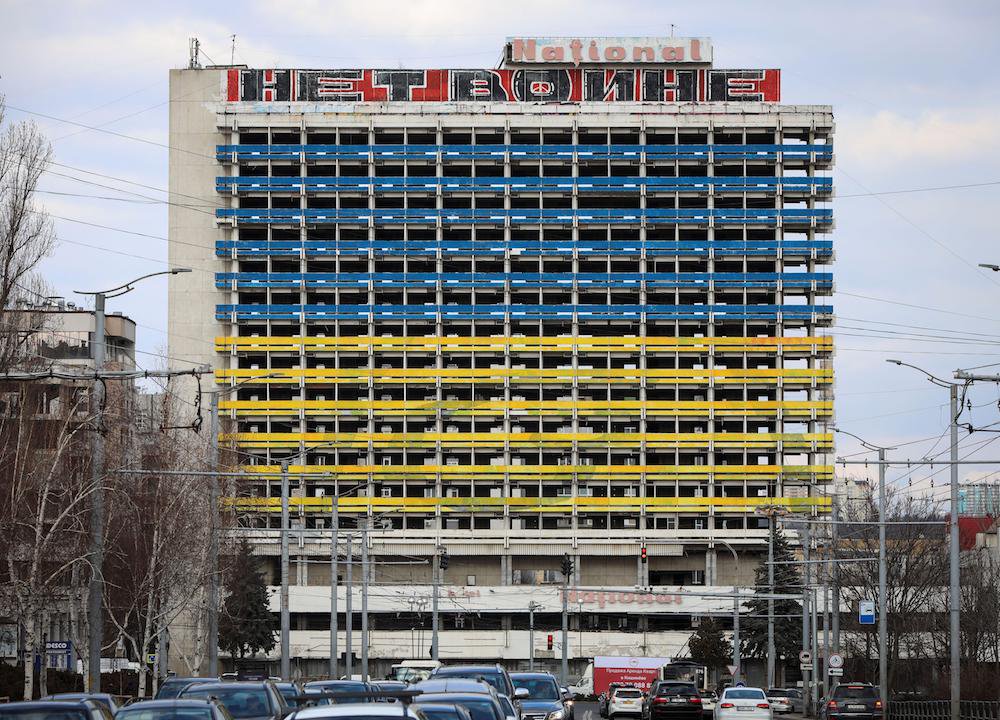 An abandoned building of the National Hotel is seen painted in Ukrainian national colours in Chisinau, Moldova. The sign reads 