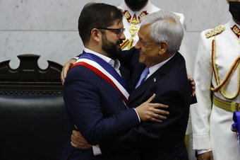 Chile's President Gabriel Boric Font (L) hugs former President Sebastian Pinera at the National Congress in Valparaiso, Chile, March 11, 2022