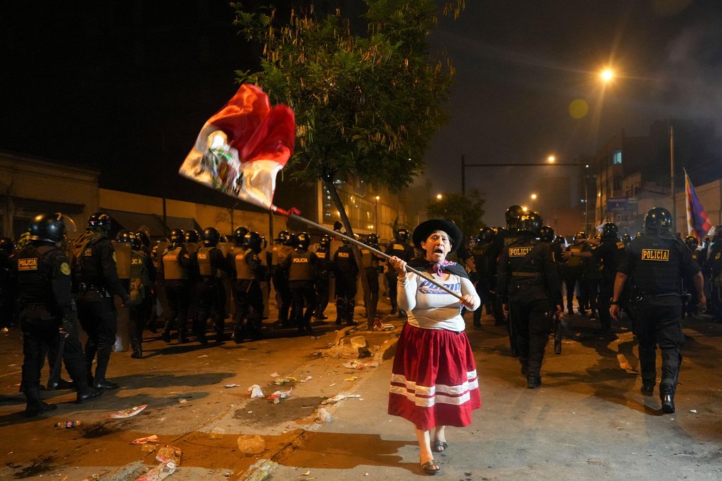 A woman waves a Peruvian flag during an anti-government protest in Lima, Peru, Friday, Jan. 20, 2023.