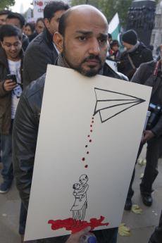 Protester at anti-drone demo in London with graphic image of how drones kill