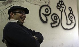 Ahmed Maher next to a graffito saying 'resist'. Demotix/Roger Anis. ALl rights reserved.