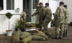 The army in front of a flooded house in Surrey