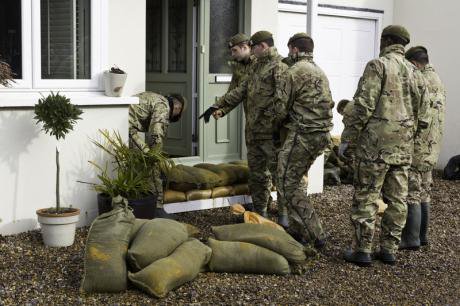 The army in front of a flooded house in Surrey