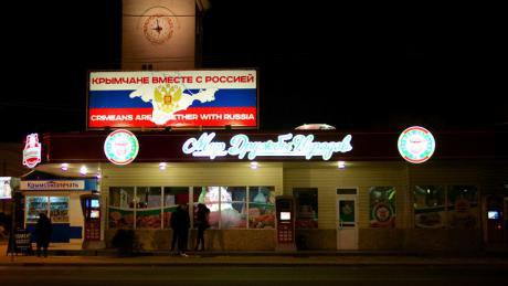 A sign above a restaurant reads in English and Russian 'Crimeans are together with Russia'