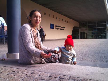 Roma woman and child beg in front of the European Commission building.