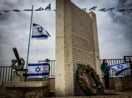  Israeli youth in northern Galilee hold flags at attention near a memorial to casualties in the Israe