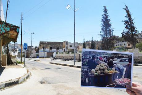 A photo contrasts life in a busy Hebron market (1999) with life on that street since the centre of Hebron was closed to Palestin