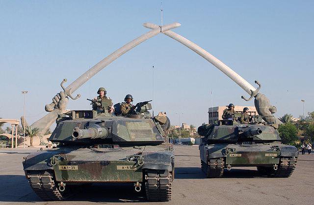 US tanks pose in front of the "Hands of Victory" monument, Baghdad, 2003. Wikimedia Commons/Public Domain.