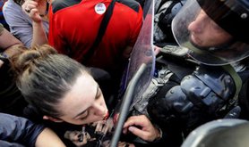 Woman applies lipstick in riot shield in Macedonia