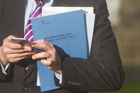 An MP holds the 2015 Autumn statement spending review booklet.