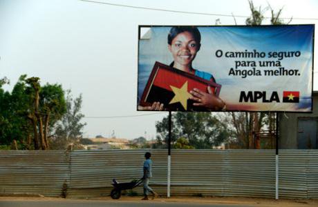A boy with an empty wheelbarrow walks underneath an MPLA propaganda banner in the town of Menongue. Demotix. All rights reserved._0.jpg