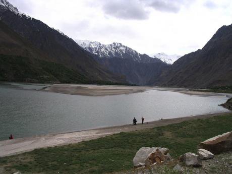 A narrow river runs through the picture, dividing the foreground and background. One side is Afghnistan, the other Tajikistan