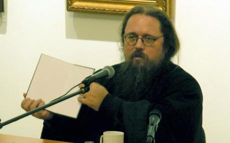 Andrei Kurayev at a talk. He is wearing black clothes, has an untamed beard and round glasses.