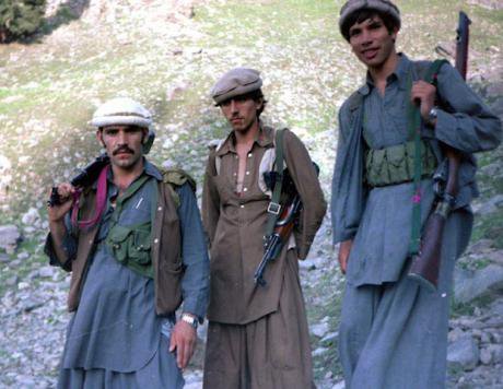 Afghan Mujahideen, dressed in traditional pashto clothing, pose with their rifles.