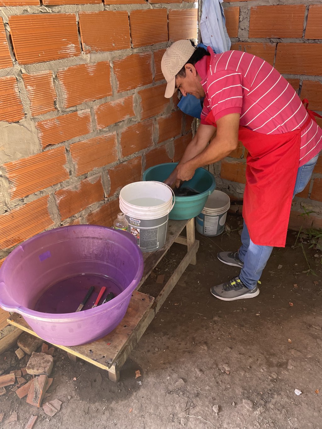An activist of the Polo Obrero washes kitchen utensils in buckets at the Nueva Unión pot in the Villa Unión seizure