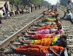 Women lying along a train track