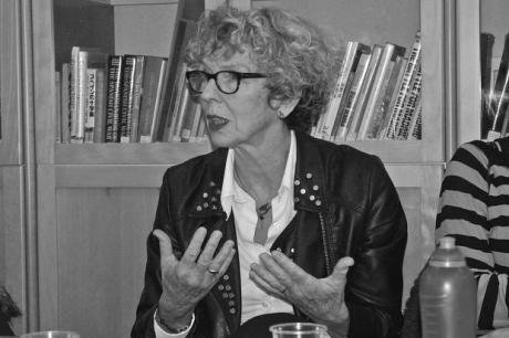 Photo of spectacled, curly-haired woman talking