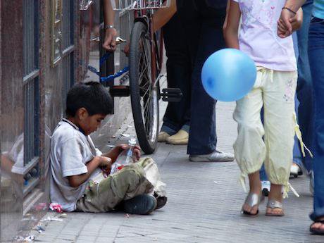 Boy is ignored as he sits on the pavement in Rosario, Argentina. Pablo Flores/Flickr. Some rights reserved.