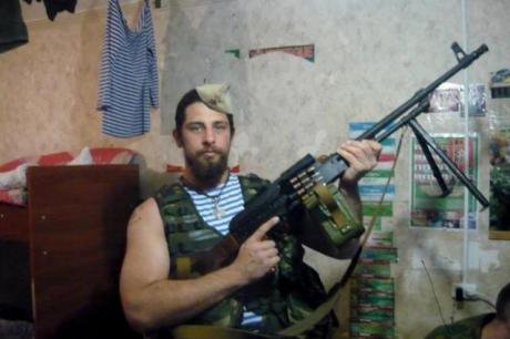 Rafael poses with a light machine gun in military fatigues.