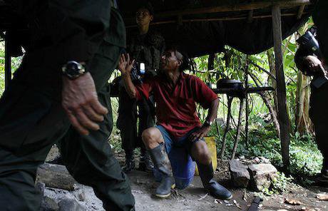 A coca farmer worker speaks with police, Colombia. Flickr / Policia Colombia. Some rights reserved.