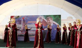 Women from Chechnya's ministry of culture displaying 'ideal' Chechen dress. Behind them is a picture of President Kadyrov.