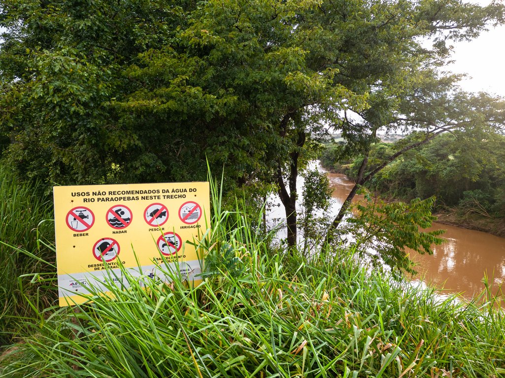 Una señal en las orillas del río Paraopeba con mensajes que prohíben las actividades de pesca, nadar, beber o utilizar el agua para la agricultura, São Joaquim de Bicas, Minas Gerais, Brasil