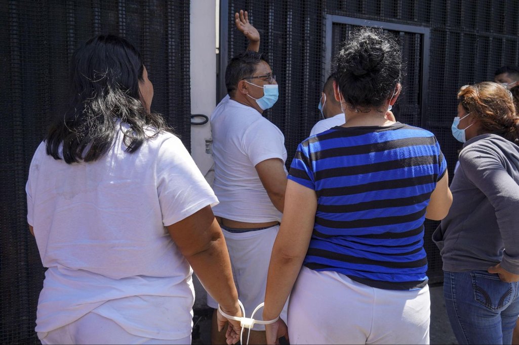 Alleged gang members are seen handcuffed before entering a detention centre in San Salvador, June 2022