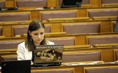 Far-right politician Duro Dora with laptop sticker &#39;the nation lives in its womb&#39;. Credit - Magyar Narancs (1).jpg