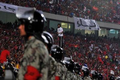 Line of police with the stadium crowd in the background.