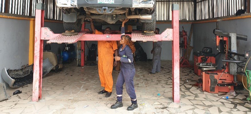 Florence Iria at work with car on lift