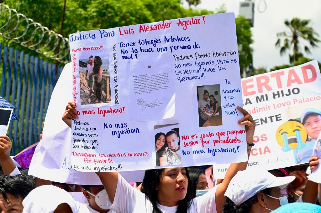 Durante una protesta en El Salvador, una mujer levanta una pancarta exigiendo la liberación de un familiar que asegura es inocente.