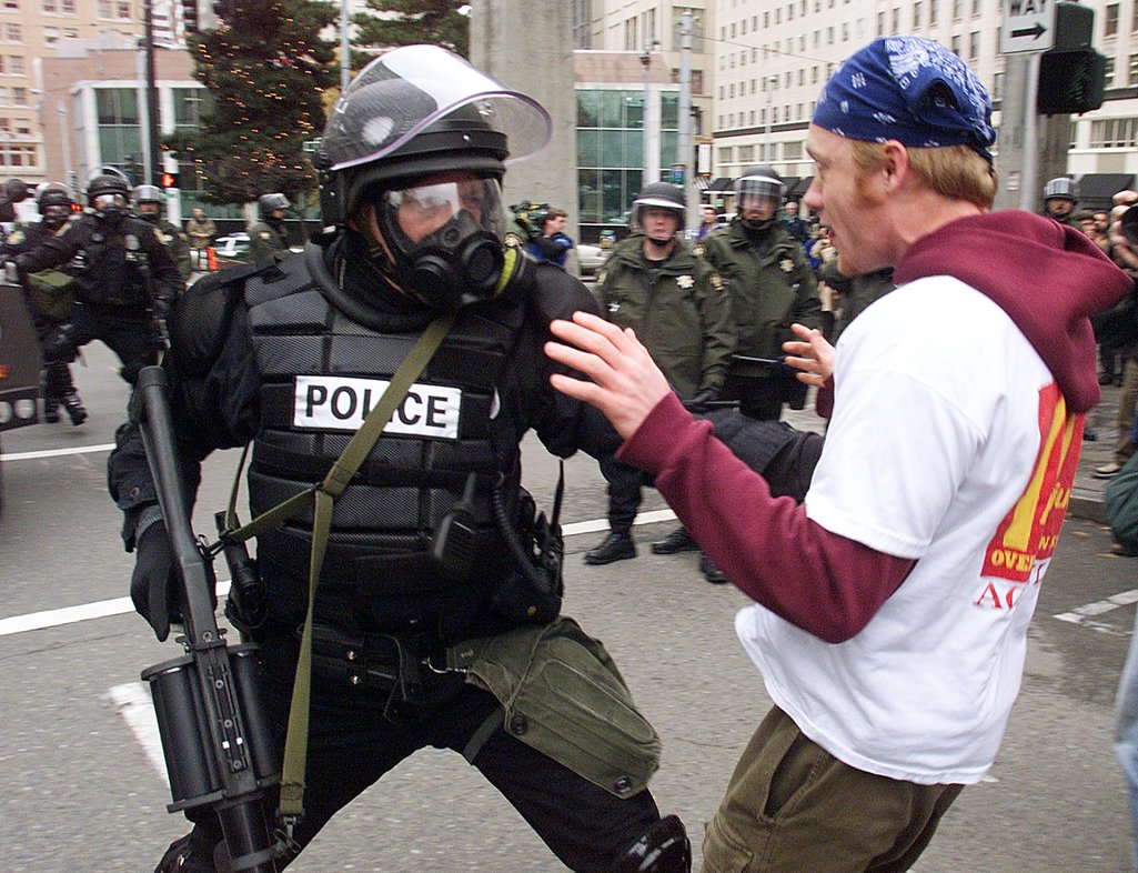 Policjant zamieszek popycha demonstranta w Seattle, 1 grudnia 1999 r