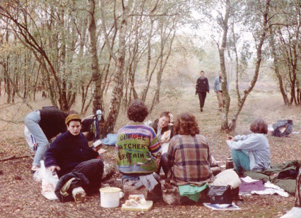 Women sit on the floor in a forest