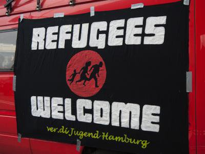A sign welcoming refugees is hung from a school bus in Hamburg