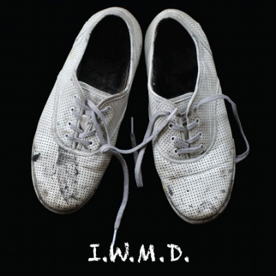 Dirty, white canvas shoes with 'I.W.M.D.' written underneath.