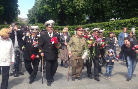 Veterans march to lay flowers at a monument to the dead.